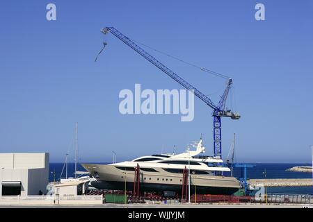 Spiaggiata barca con gru su storage area di yacht di lusso Foto Stock