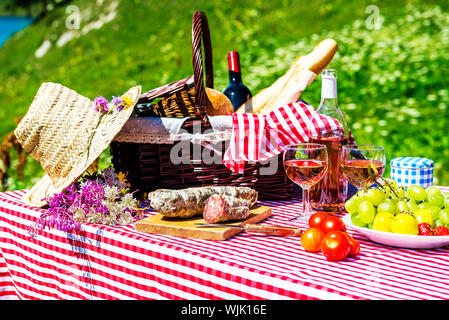 Assaggiato picnic sul prato vicino a un lago Foto Stock