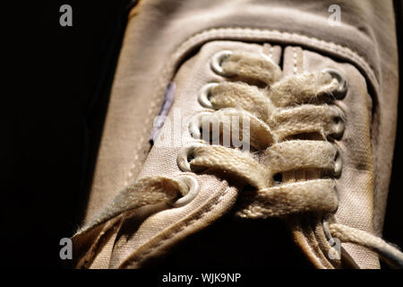 Corda di bianco sneakers in sfondo nero Foto Stock