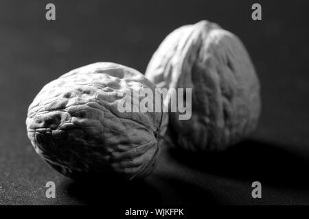 Due noci comuni con guscio su sfondo nero Foto Stock