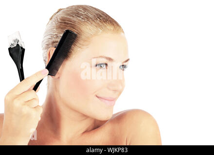 Bella donna bionda la tintura dei capelli, l'applicazione di crema colorante, la cura dei capelli e salone di parrucchiere, di bellezza il concetto di trattamento Foto Stock