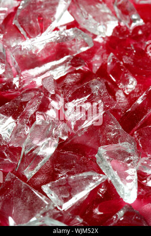 Il vetro rotto pezzi su rosso sangue finto, come sfondo a trama Foto Stock