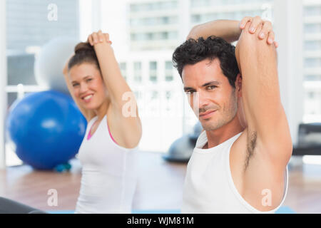 Ritratto di due sportivi stretching mani alla classe di yoga in studio fitness Foto Stock