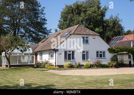 Emsworth, Hampshire, Regno Unito un tipico inglese bungalow con un prato verde e fiori nel giardino anteriore Foto Stock