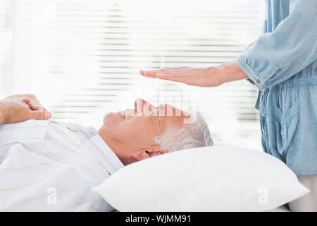 Terapista del massaggio reiki esegue su alti man a health spa Foto Stock