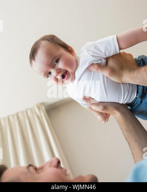 Ritratto di Allegro baby boy essendo portati dal padre a casa Foto Stock