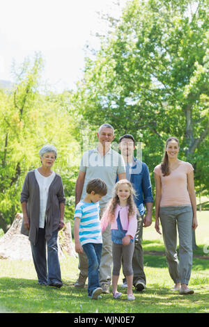 Lunghezza completa di una felice famiglia estesa a piedi nel parco Foto Stock