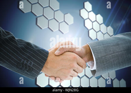 Immagine composita di handshake business contro sfondo tecnologico con esagoni Foto Stock