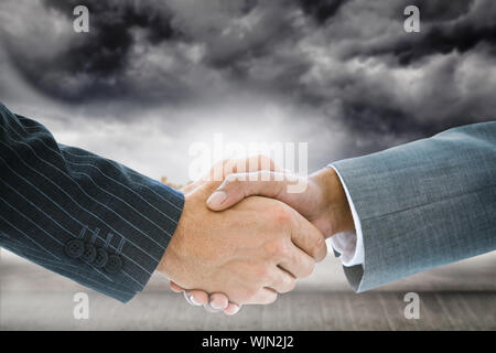 Immagine composita di handshake business contro sfondo tecnologico con esagoni Foto Stock