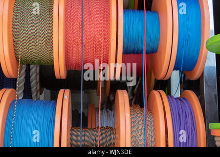 Side Shot delle stringhe avvolto intorno alla bobina. Corde in bianco, blu, rosso, colore giallo. Spese di spedizione e le funi utilizzate nell'industria Foto Stock