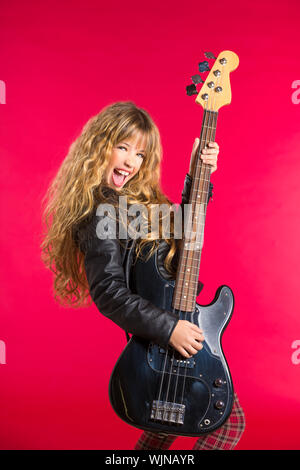 Blonde rock and roll girl suonare chitarra basso su sfondo rosso Foto Stock