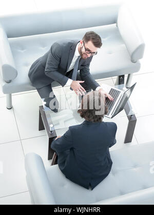 Due imprenditori Discutere compiti seduti al tavolo per ufficio. Foto Stock