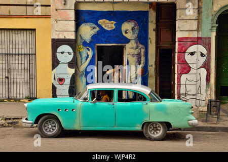 Street photography nel centro di Avana- pitture murali e auto parcheggiata lungo il Paseo de Marti (Prado), La Habana (Avana), La Habana, Cuba Foto Stock