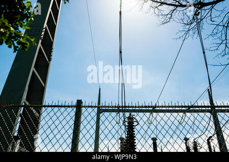 Basso angolo di visione di alta tensione francese le linee di potenza contro il cielo blu sullo sfondo alla centrale idroelettrica di Centrale Hydroelectrique de Gambsheim Foto Stock
