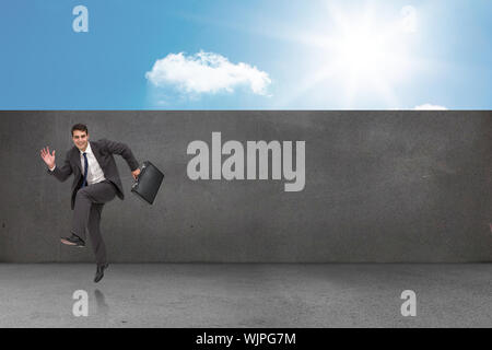 Happy businessman in un hury contro il balcone e il cielo luminoso Foto Stock