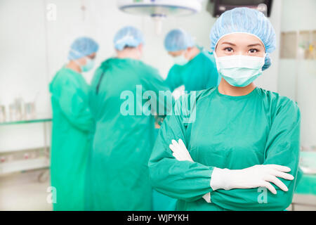 Fiducioso chirurghi femmina due mani incrociate con i team Foto Stock