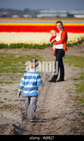 Madre di due bambini nel campo di tulipani Foto Stock