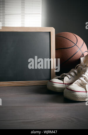 White sneakers con basket e lavagna vuota con copyspace. Foto Stock