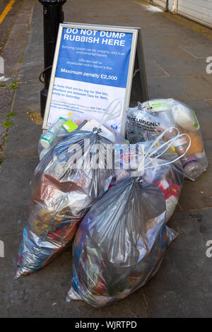 London, Regno Unito - 21 Maggio 2018: gruppo di sacchetti di plastica contenenti rifiuti per il dumping sul marciapiede Foto Stock