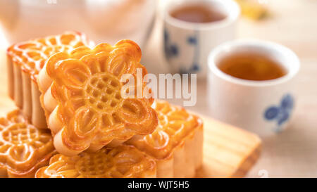 La torta della luna con tè sul luminoso tavolo in legno e serve provare, concetto di vacanza del Mid-Autumn Festival del cibo tradizionale layout design, vicino, copia spac Foto Stock