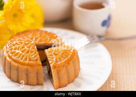 La torta della luna con tè sul luminoso tavolo in legno e serve provare, concetto di vacanza del Mid-Autumn Festival del cibo tradizionale layout design, vicino, copia spac Foto Stock