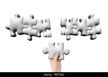 Tenere in mano un puzzle pezzo, isolato su bianco. Foto Stock