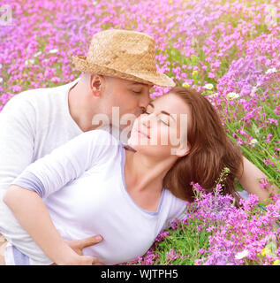 Famiglia giovane kissing in giardino Foto Stock