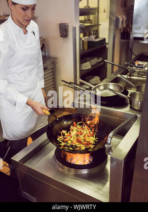Femmina concentrato chef preparare il cibo in cucina Foto Stock