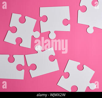 Bianco grande puzzle in bianco su sfondo rosa, vista dall'alto Foto Stock