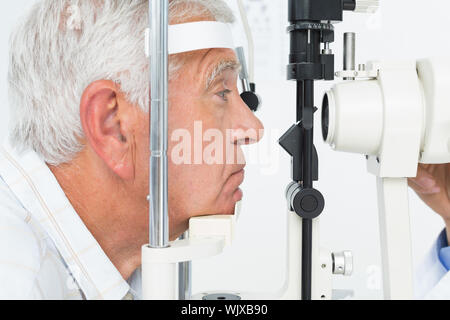 Close-up vista laterale di un anziano uomo ottenendo la sua cornea selezionata Foto Stock