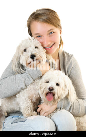 Bella ragazza adolescente tenendo due adorabili coton de tuléar cani Foto Stock