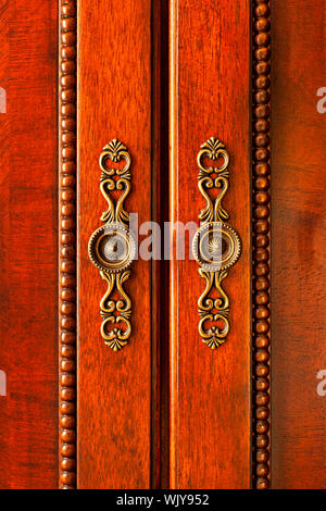 Ornato maniglie sul mobiletto in legno Porte closeup Foto Stock