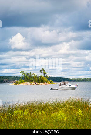 Il motoscafo ancorato con dinghy sul lago in Georgian Bay, Ontario, Canada Foto Stock