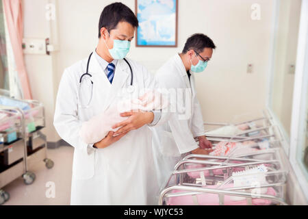 Medico ginecologo tenendo un neonato Foto Stock