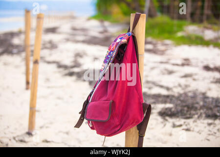 Zaino rosso sul recinto su una deserta isola tropicale Foto Stock