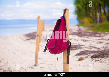 Zaino rosso sul recinto su una deserta isola tropicale Foto Stock