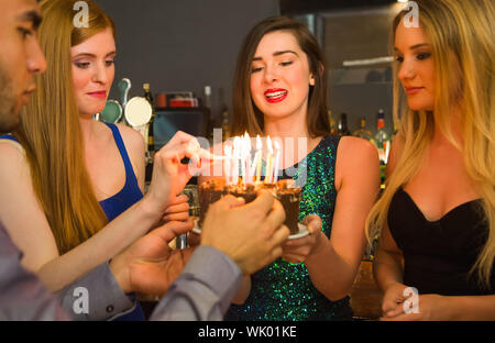 Happy amici preparare la torta di compleanno Foto Stock