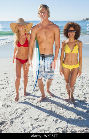 Tre amici percorrendo a piedi sulla spiaggia Foto Stock