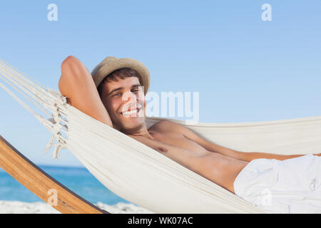 Uomo sorridente indossando cappello di paglia alla ricerca Foto Stock