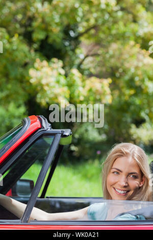 Felice donna bionda la guida red cabriolet Foto Stock