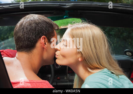 Attraente bionda baciare il suo fidanzato Foto Stock