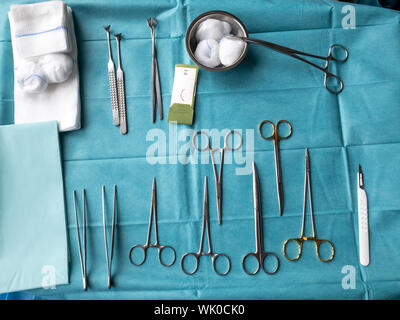 Vari strumenti chirurgici giacciono su di un piano operativo Foto Stock