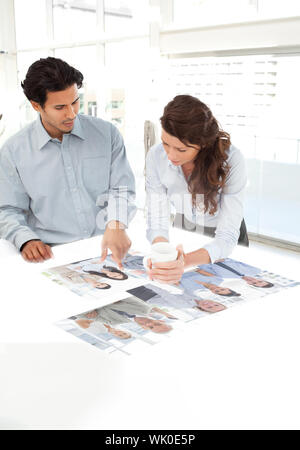 Giovani colleghi che lavorano insieme con interfaccia digitale Foto Stock