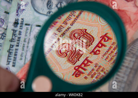 Banconote indiano visto attraverso la lente di ingrandimento Foto Stock