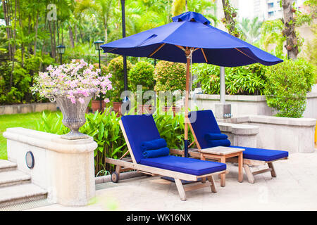 Chaise longue vicino alla piscina nel resort di lusso Foto Stock