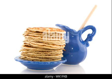 Molti pancake con un può di sciroppo isolato su bianco Foto Stock