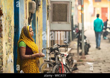 Varanasi (India). Una donna indiana è acquistare verdure da un venditore ambulante per le strade di Varanasi. Foto Stock