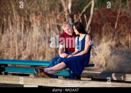 Giovani interracial giovane tranquillamente pregando insieme sul molo in legno su acqua Foto Stock