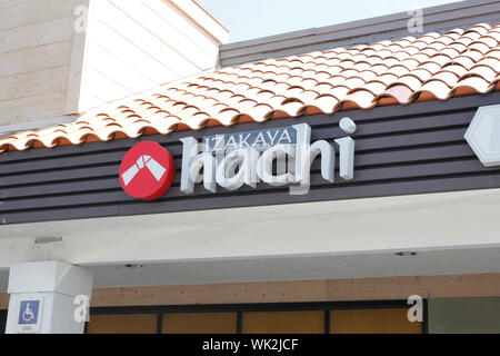Un negozio di fronte segno per il ristorante noto come Izakaya Hachi Foto Stock