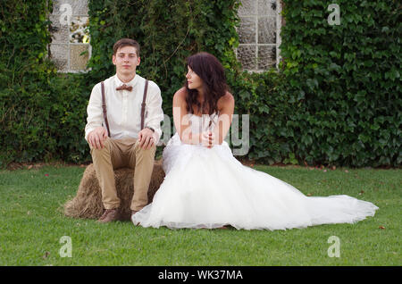 Hillbilly hipster stile vintage sposa e lo sposo al di fuori di una chiesa dopo la cerimonia di nozze Foto Stock